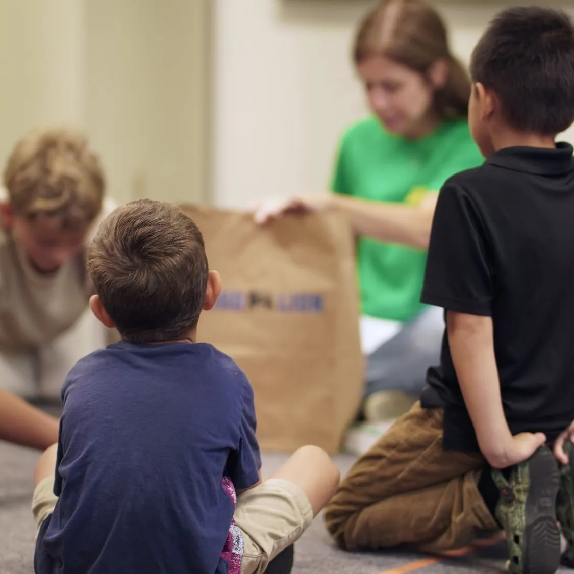 Kids gathered on the floor with a teacher in the GardenKids room