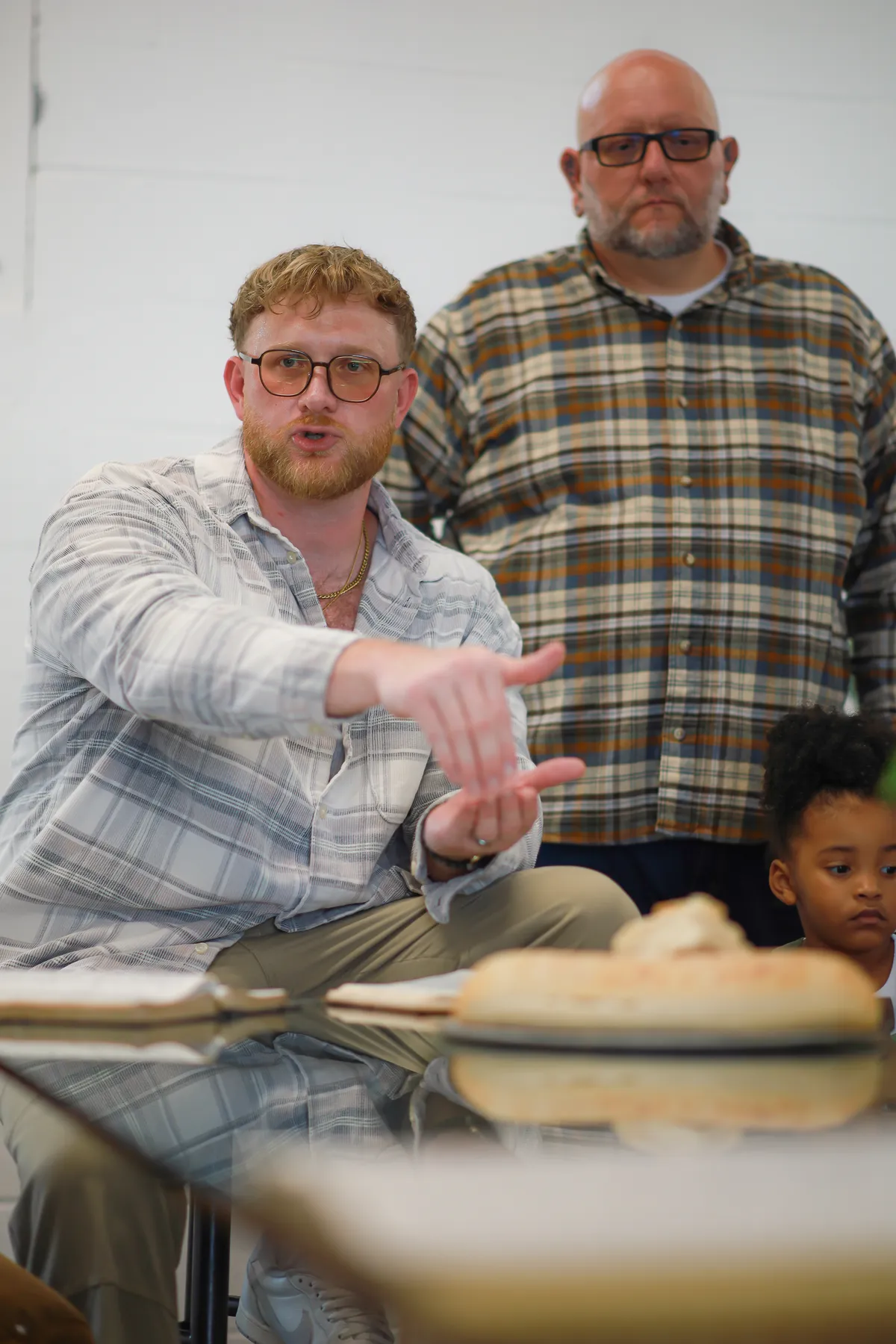 A man sharing with the group, bread on the table