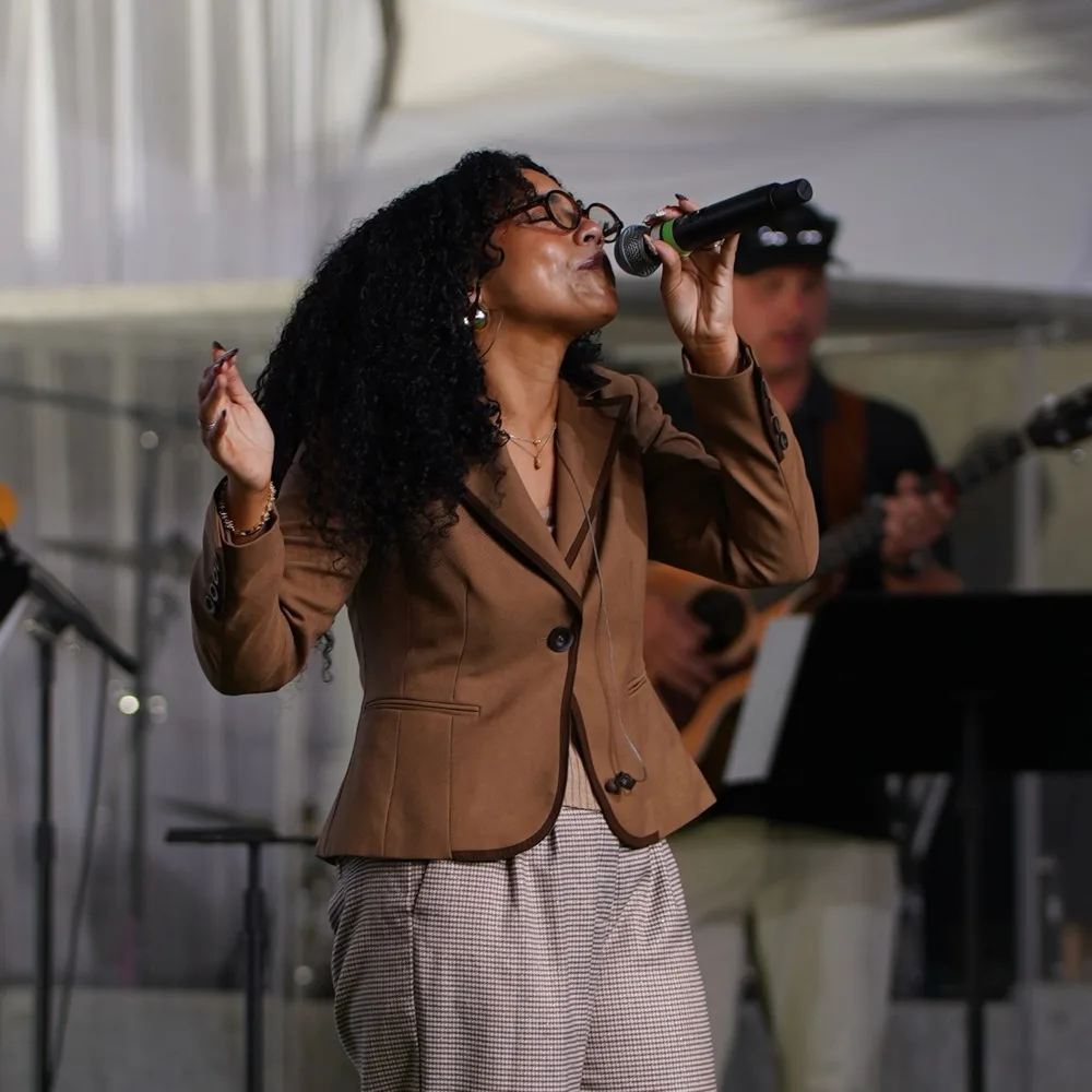 A vocalist leading worship at a Garden Co. Sunday gathering