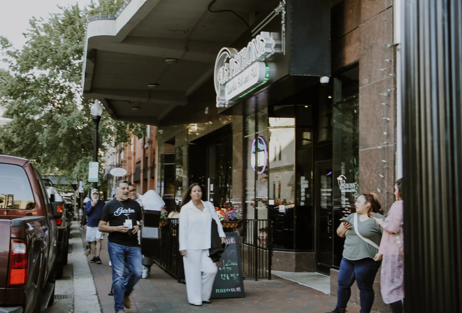 People walking past storefronts on a city sidewalk